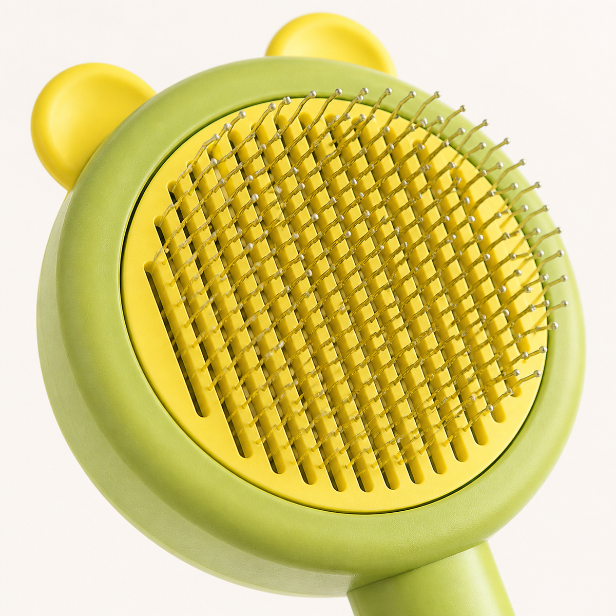 Close-up of rounded metal pins on bear-shaped pet grooming brush